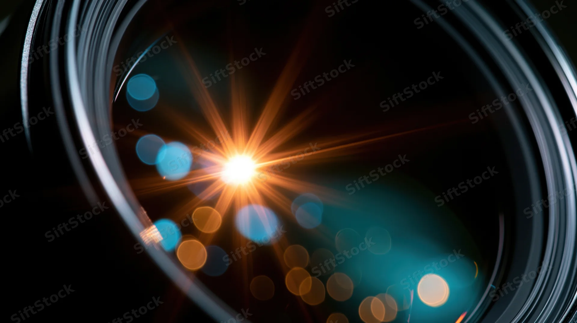 Closeup of camera lens showing light flare and bokeh effect with warm and cool tones