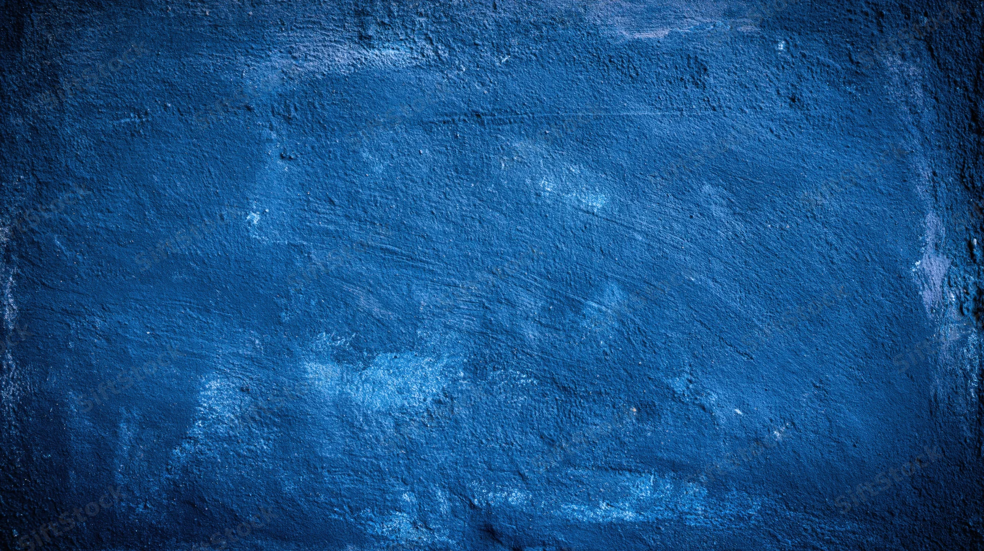 Textured blue painted wall surface with grunge finish and visible wear