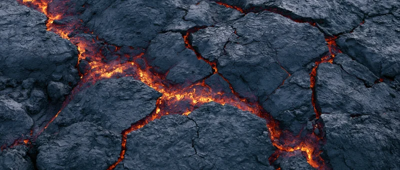 Molten lava flowing through cracks in cooled volcanic rock surface