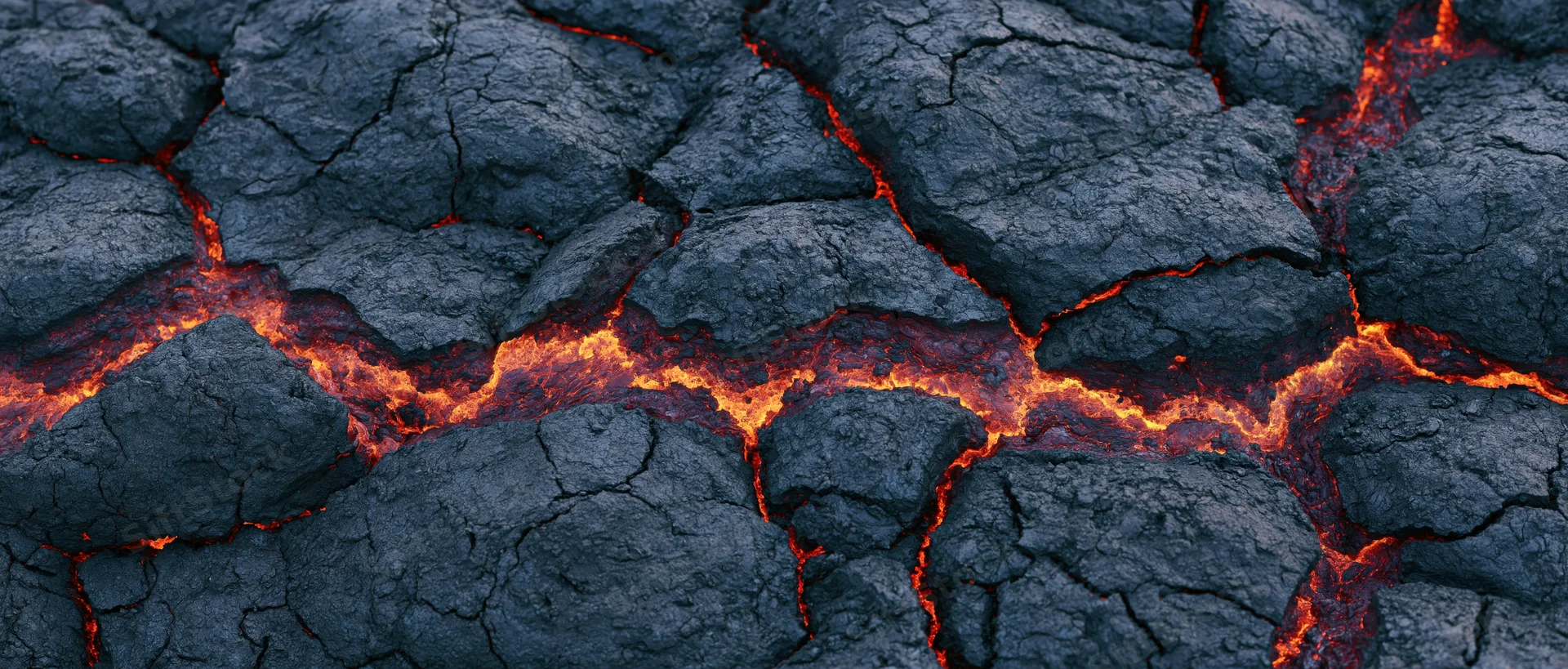 Molten lava flowing through cracks in cooled volcanic rock