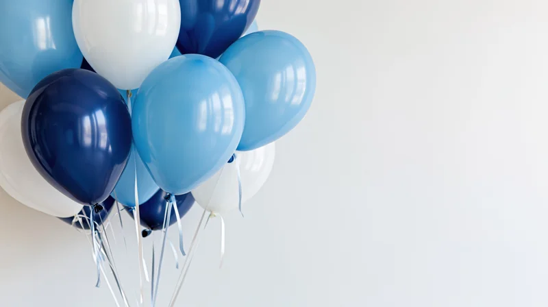 A cluster of blue and white balloons floating against a plain white background with copyspace