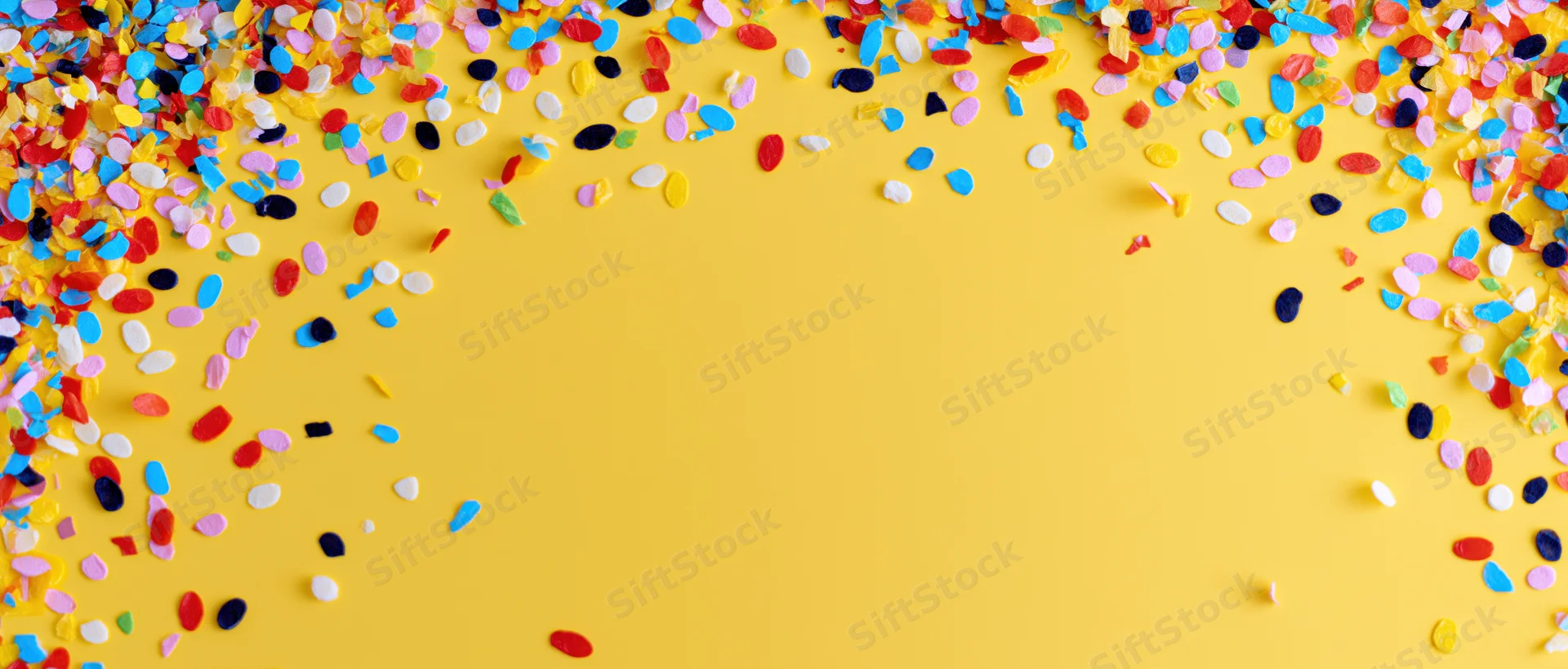 Colorful confetti scattered across yellow background with copyspace in center