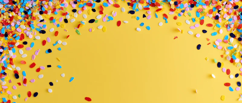 Colorful confetti scattered across yellow background with copyspace in center