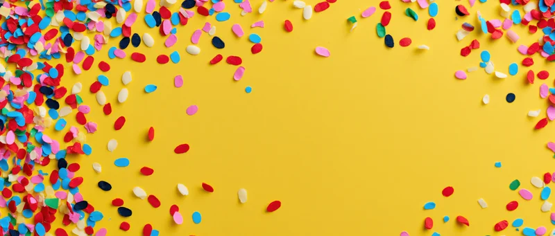 Colorful confetti scattered across yellow background forming border with copyspace in center