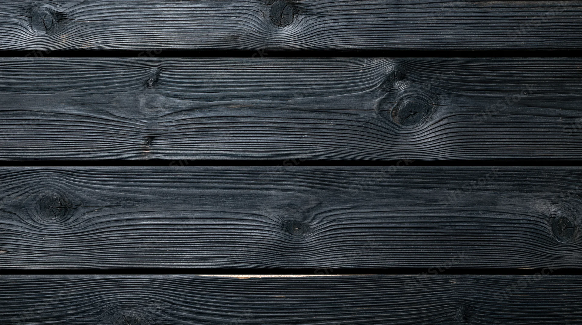 Horizontal black charred wooden planks arranged as a textured surface with visible grain and knots