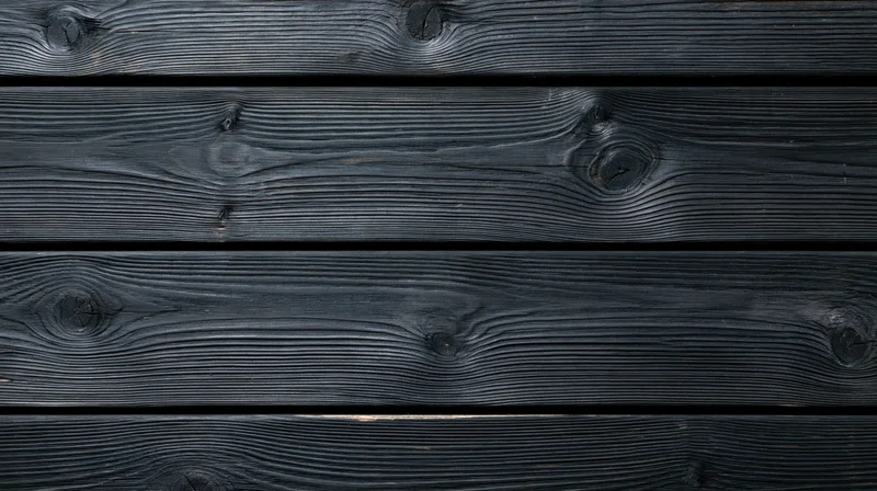 Horizontal black charred wooden planks arranged as a textured surface with visible grain and knots