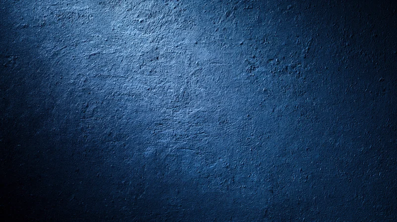 Textured blue concrete wall with gradient lighting and copyspace