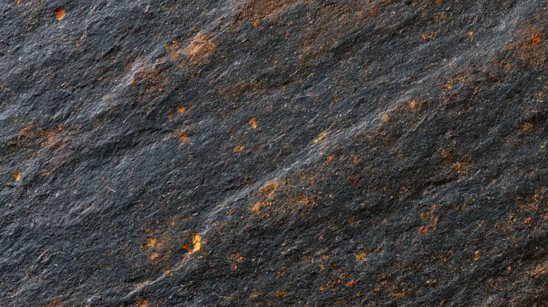 Dark slate rock surface with orange rust streaks and natural texture