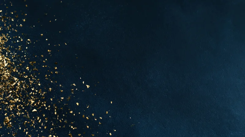Gold glitter particles scattered across dark navy blue textured background with copyspace