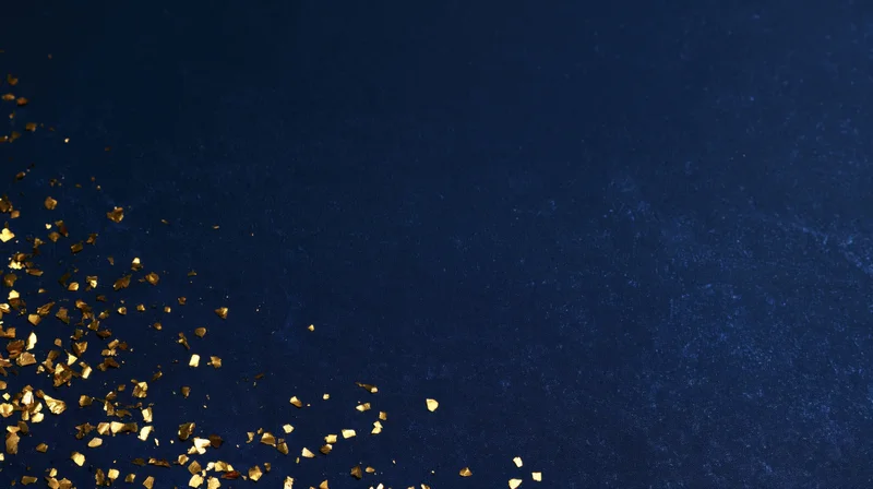 Gold confetti scattered across navy blue textured background with copyspace in upper right