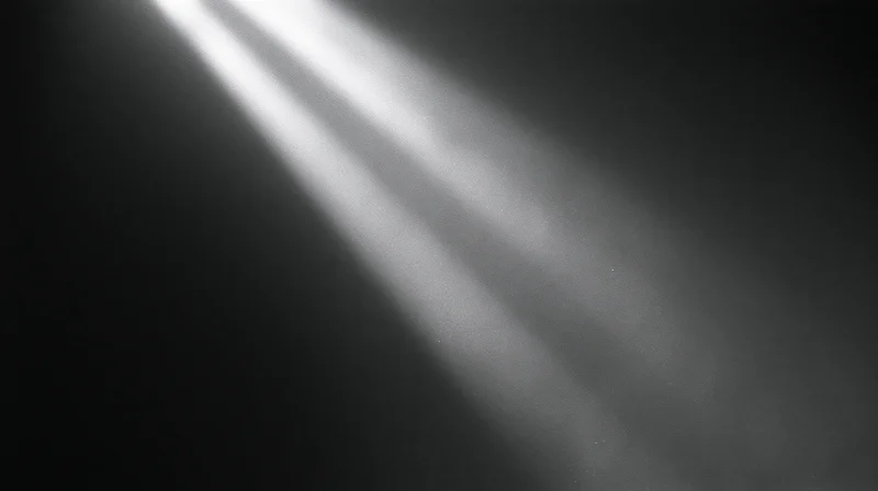 Diagonal beams of light cutting through dark space with soft haze and contrast