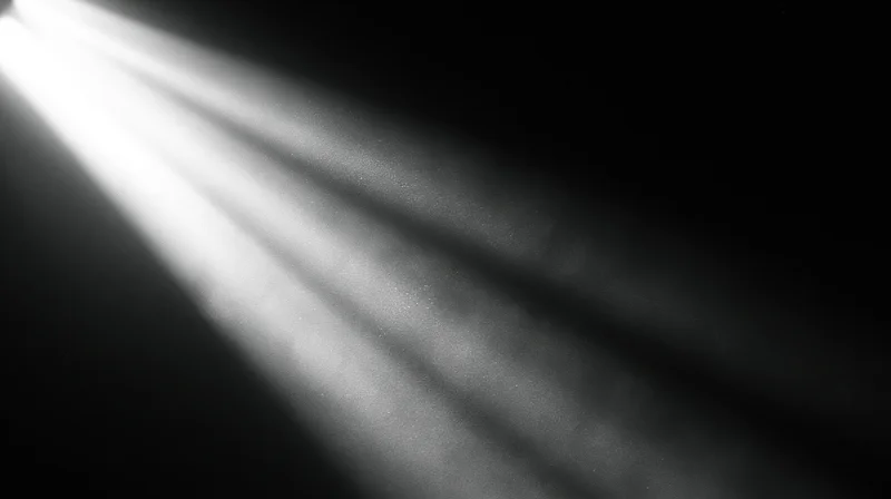 Beams of light cutting through dark space with visible dust particles suspended in air