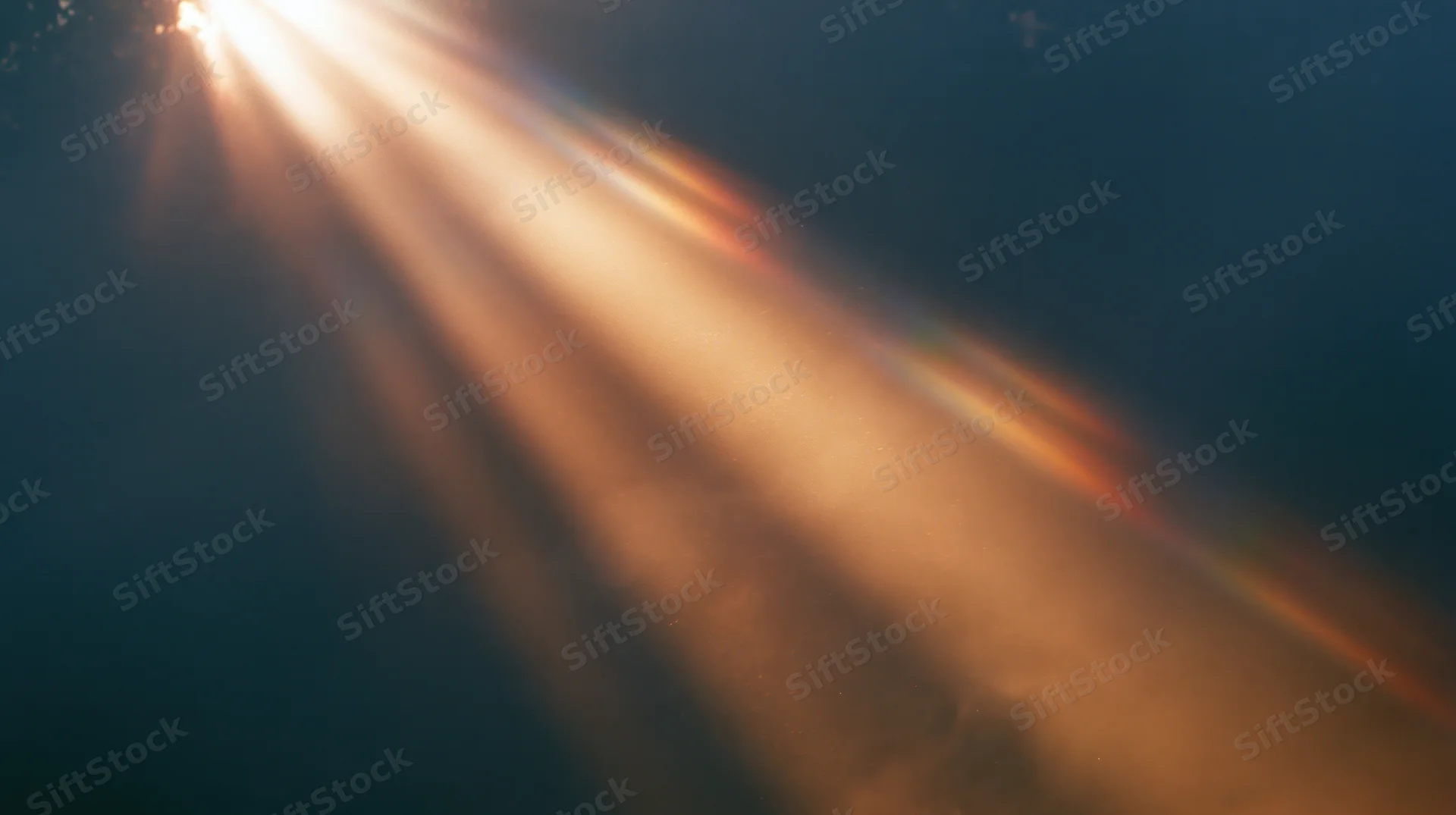 Sunbeams radiating through hazy sky with lens flare and warm glow