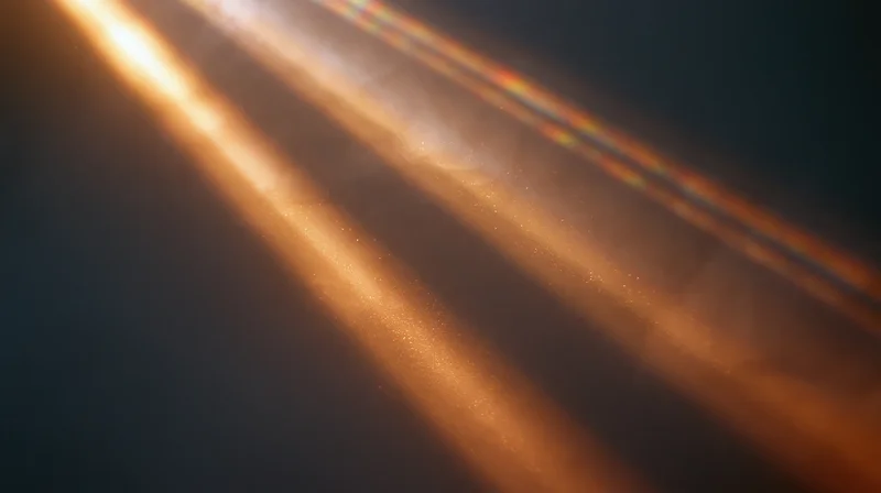 Diagonal beams of warm golden light with soft glow and floating particles against dark background