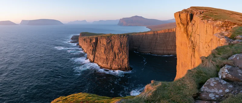 Rugged sea cliffs at sunset along the scottish coastline with waves crashing below