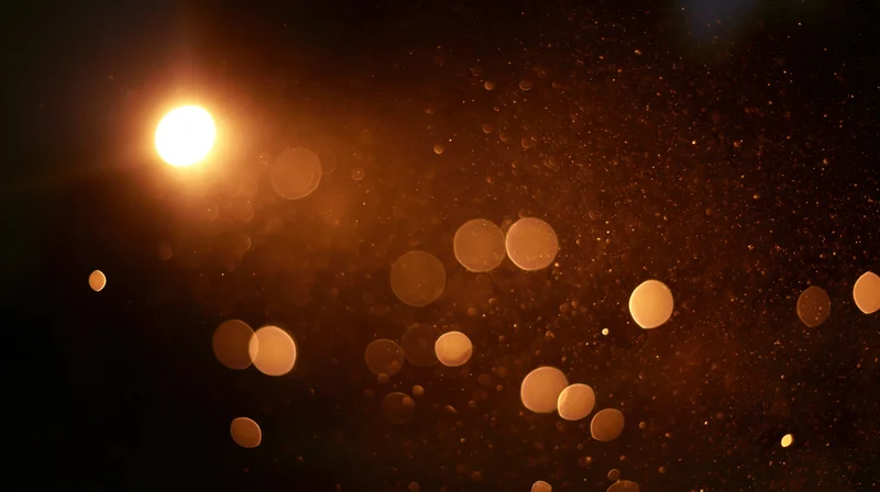 Glowing bokeh lights with floating dust particles in dark background