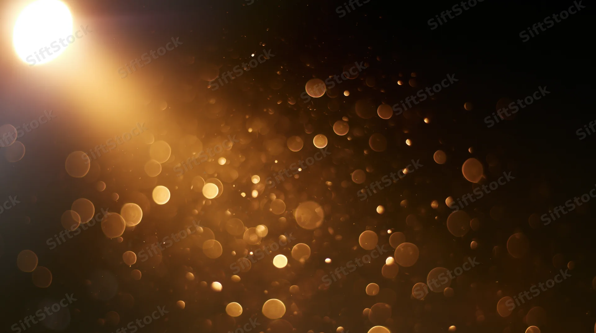 Golden bokeh lights floating in dark space with soft glow and warm ambiance