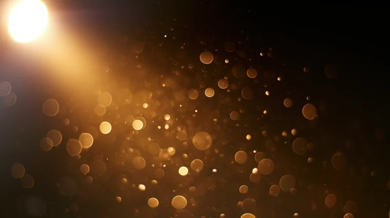 Golden bokeh lights floating in dark space with soft glow and warm ambiance