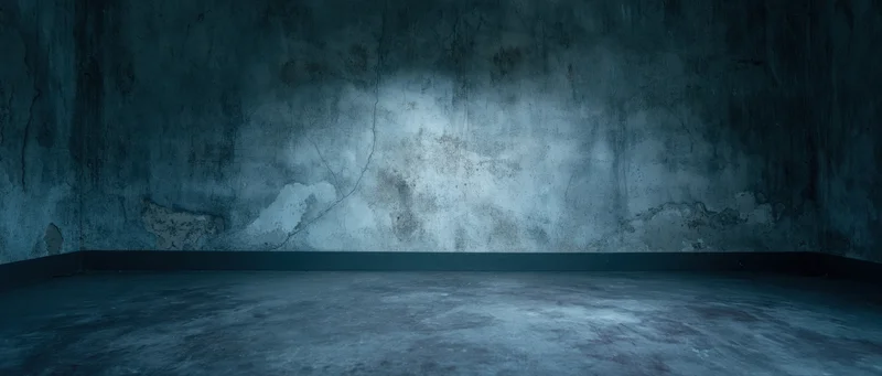 Empty industrial concrete room with cracked walls and dim blue lighting