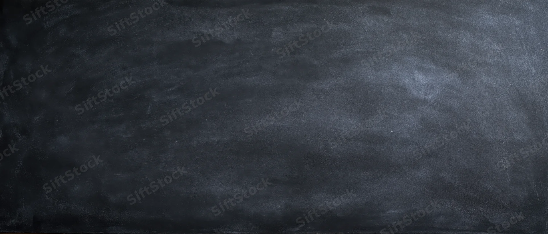Dark smudged blackboard surface with chalk residue showing erased writing in a classroom setting