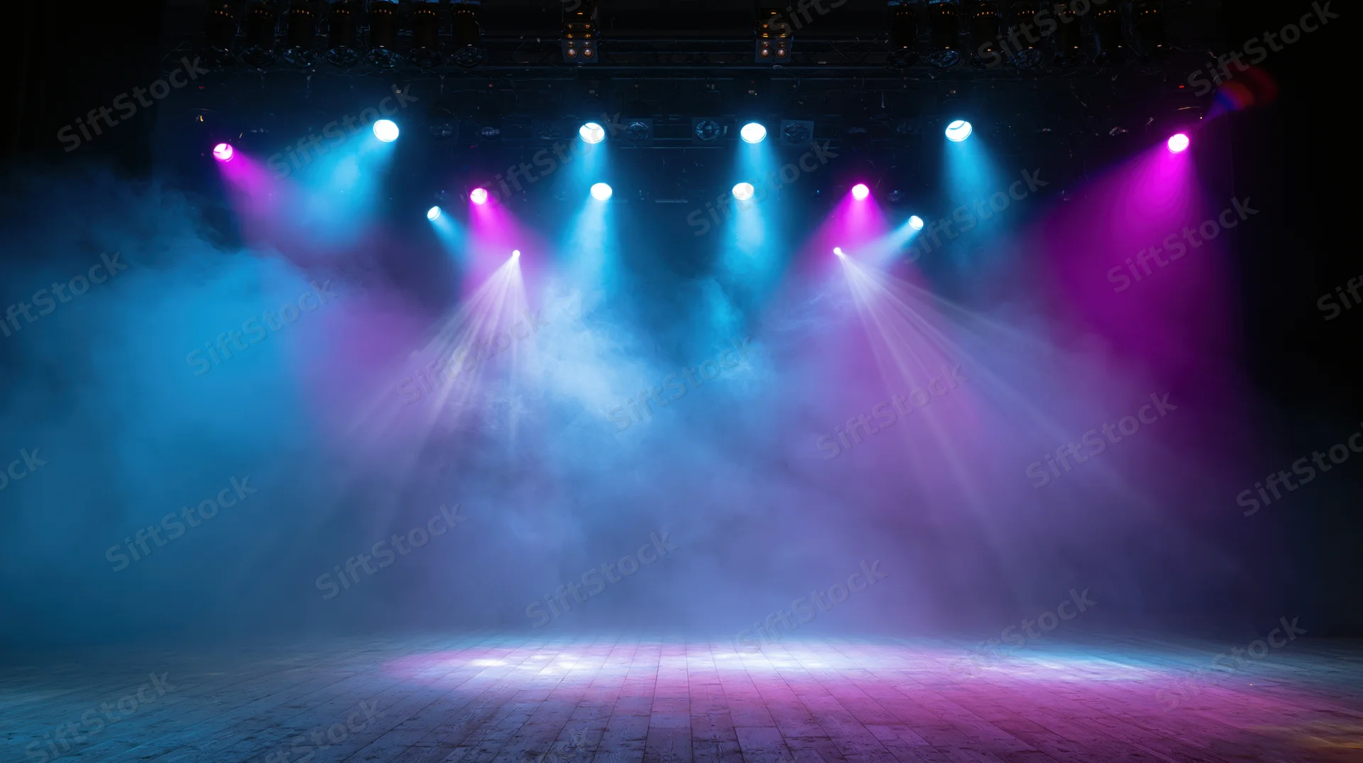 Empty stage illuminated by blue and purple spotlights with smoke in a concert venue