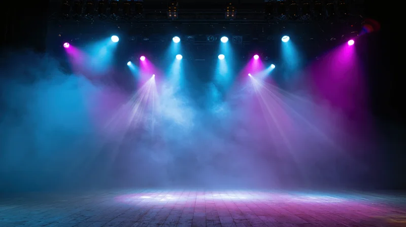 Empty stage illuminated by blue and purple spotlights with smoke in a concert venue