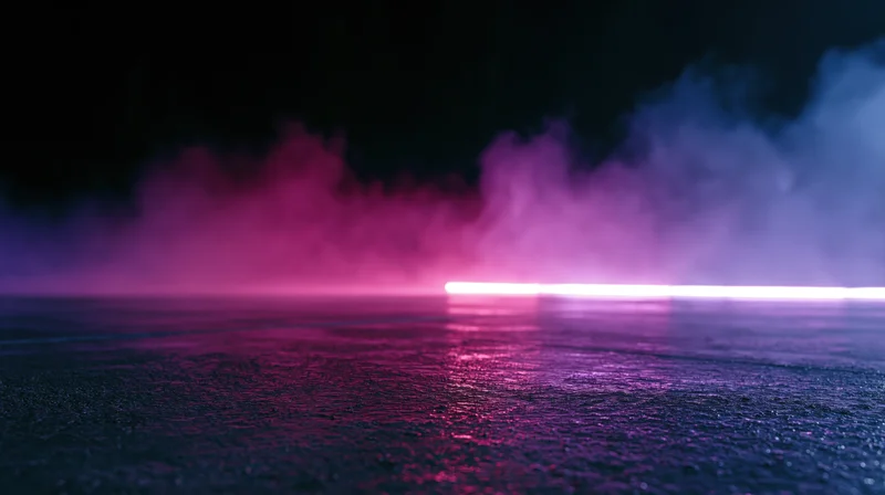 Horizontal neon light strip glowing on wet concrete floor with purple and pink smoke in dark atmosphere
