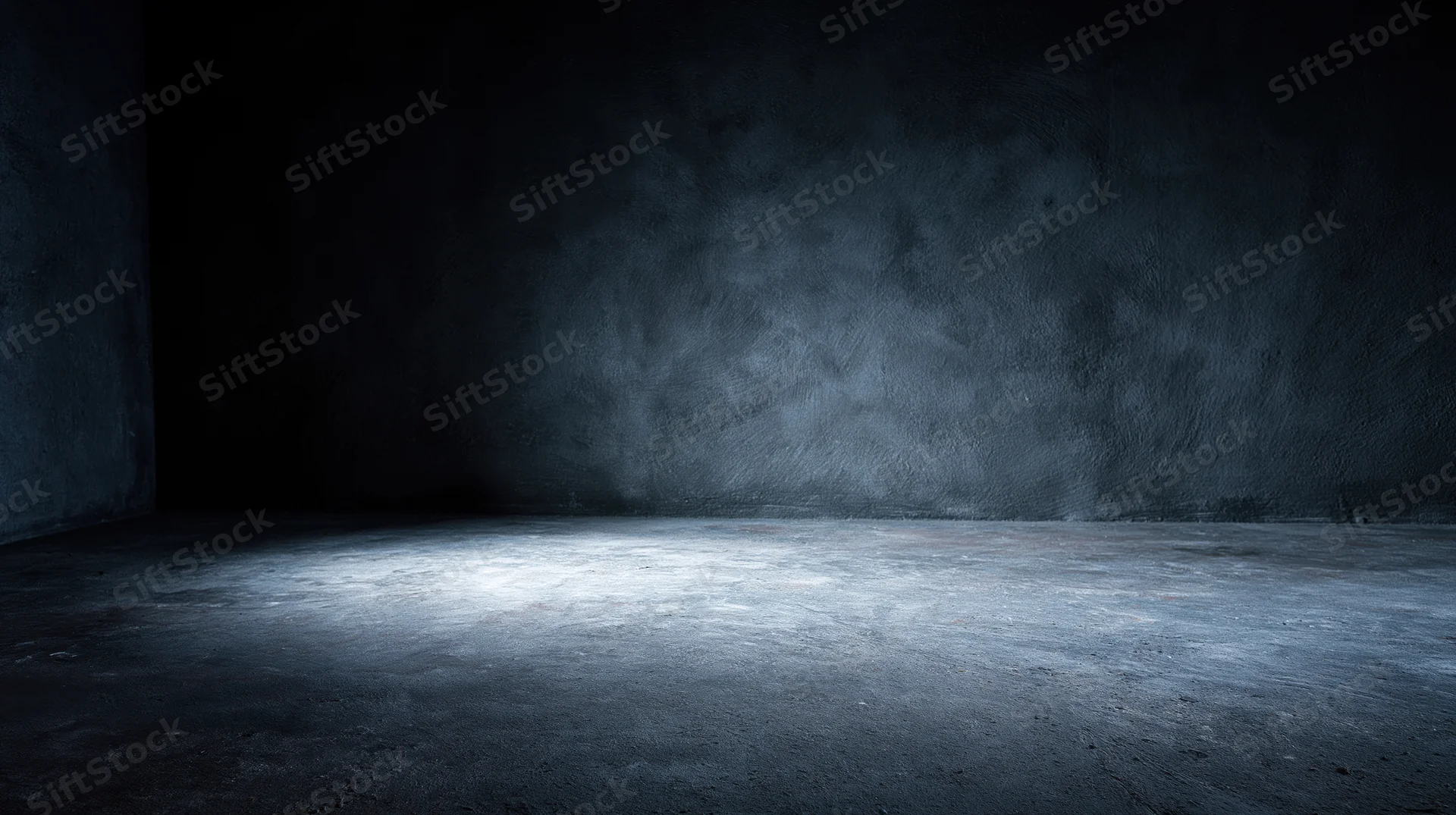 Empty concrete room illuminated by a spotlight in a dark interior
