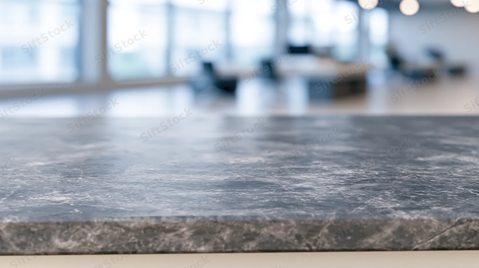 Gray marble countertop in modern office workspace with blurred background and copyspace