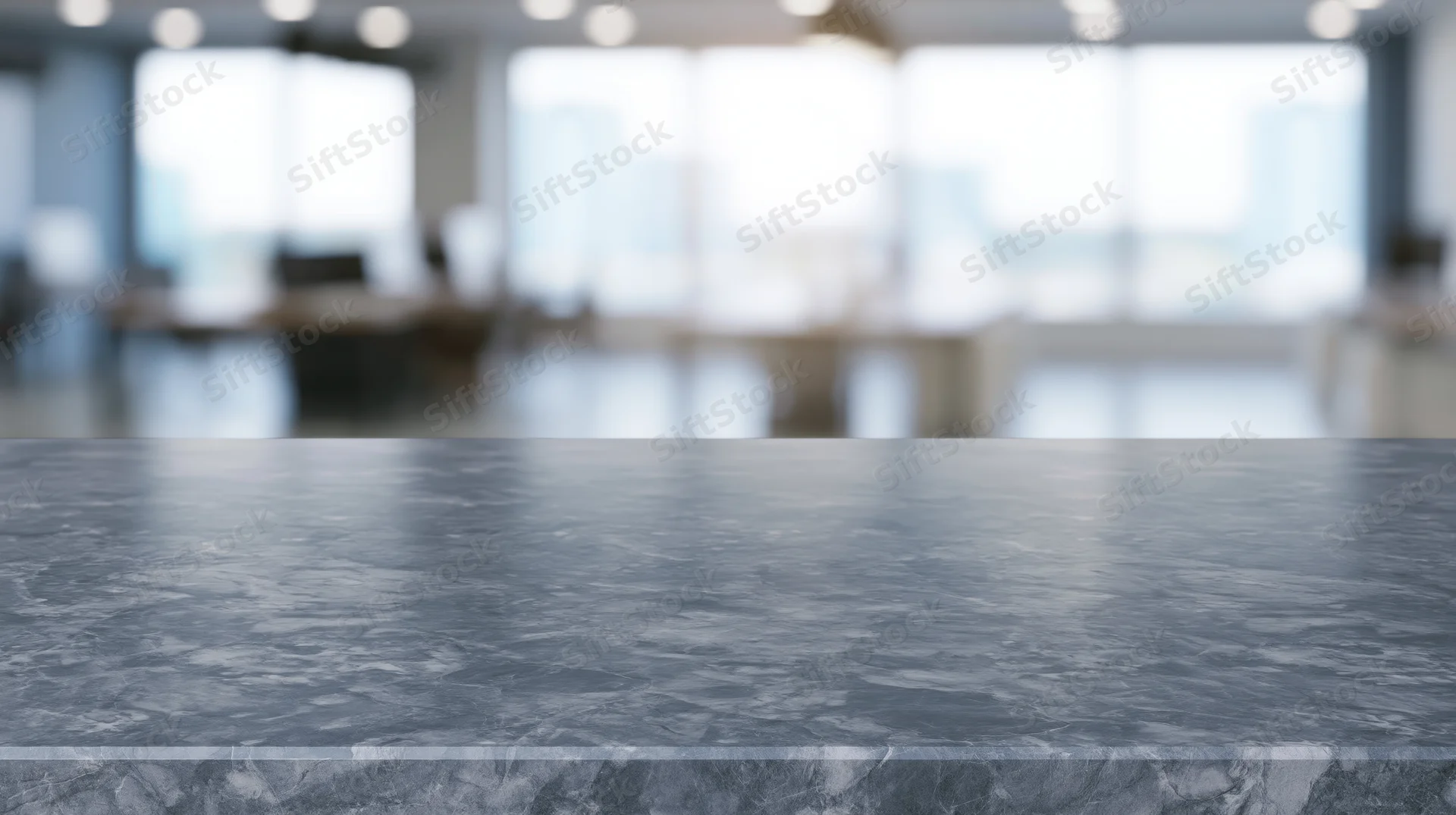 Gray marble countertop in modern office interior with blurred background and copyspace