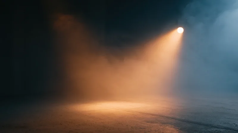 Spotlight beam cutting through smoke on a dark stage floor