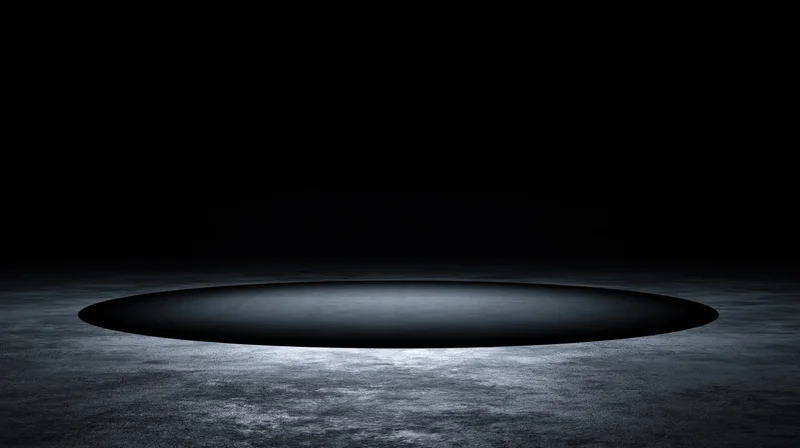 Circular spotlight on dark concrete floor in empty stage setting