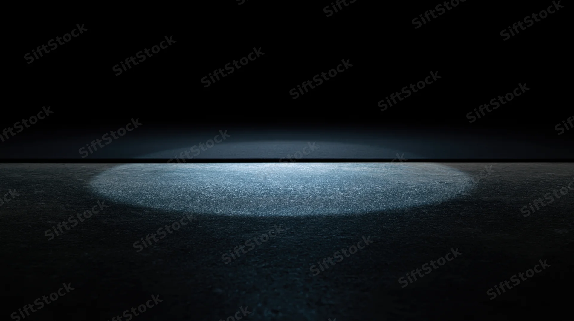 Spotlight beam on dark floor creating illuminated circular center stage area