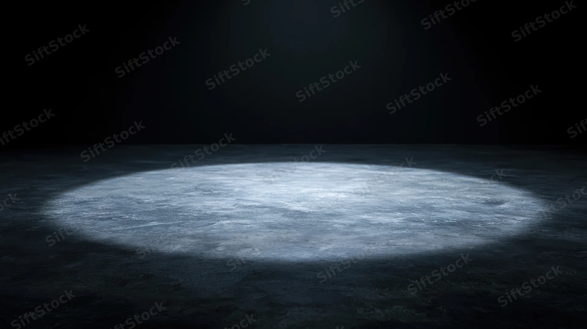 Circular spotlight on dark concrete floor in empty stage space