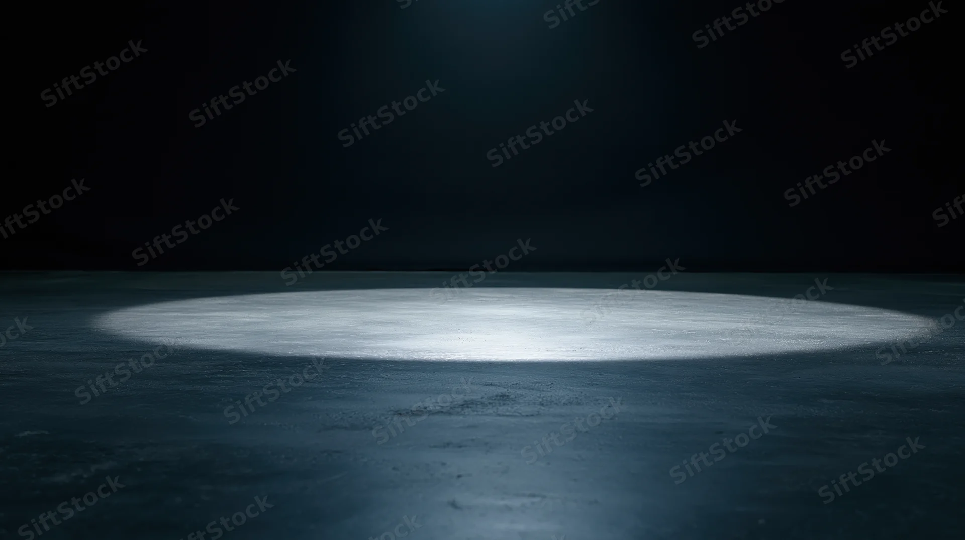 Spotlight beam on dark concrete floor in empty stage setting