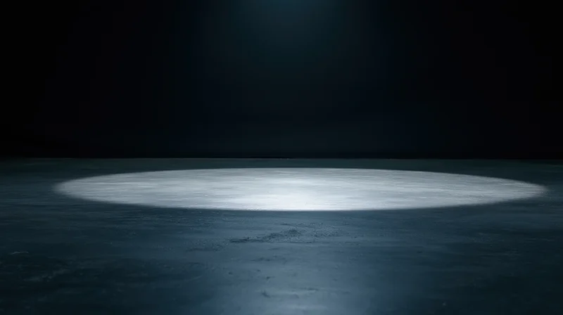 Spotlight beam on dark concrete floor in empty stage setting
