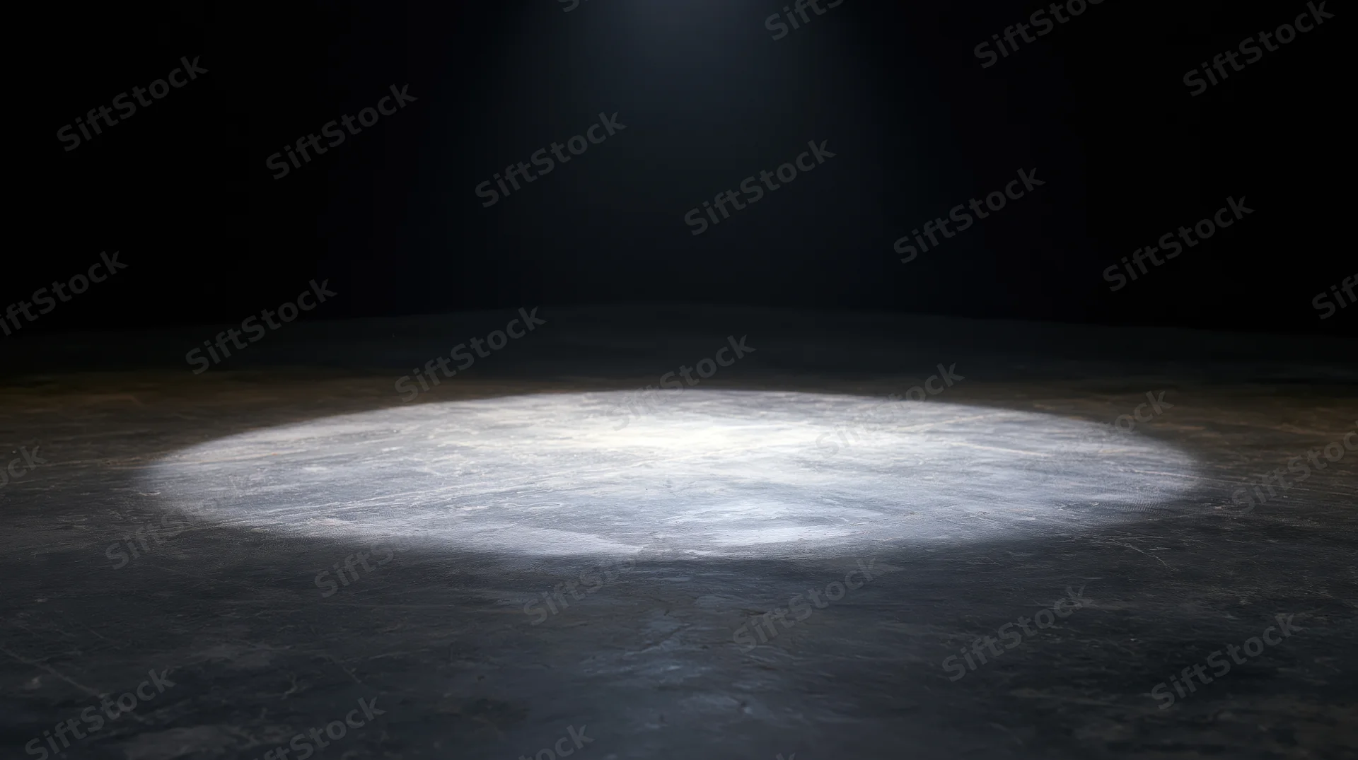 Spotlight beam on dark concrete floor in empty stage setting