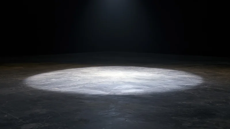 Spotlight beam on dark concrete floor in empty stage setting