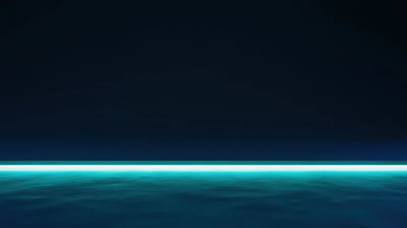 Glowing teal horizon over calm ocean at night