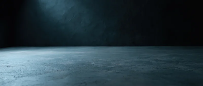 Dark blue concrete floor in an empty industrial room with shadowed walls and copyspace
