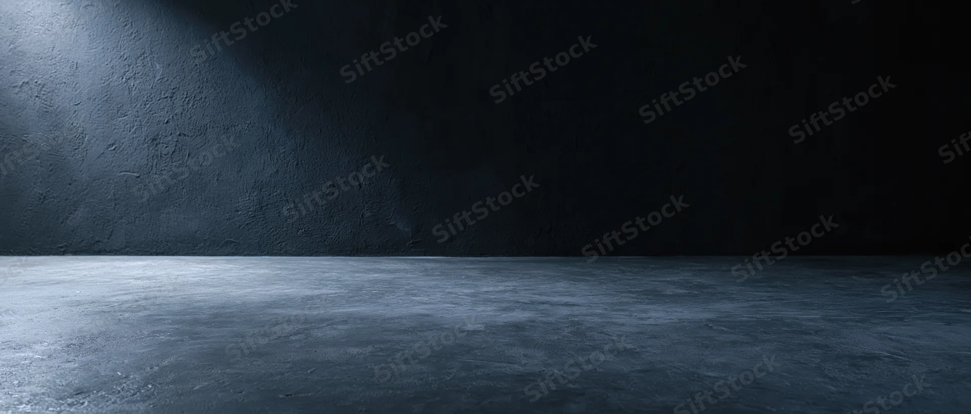 Dark empty concrete room with spotlight on textured wall and floor