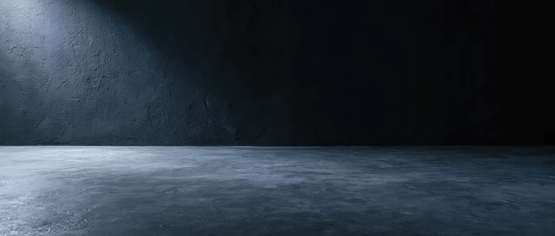Dark empty concrete room with spotlight on textured wall and floor