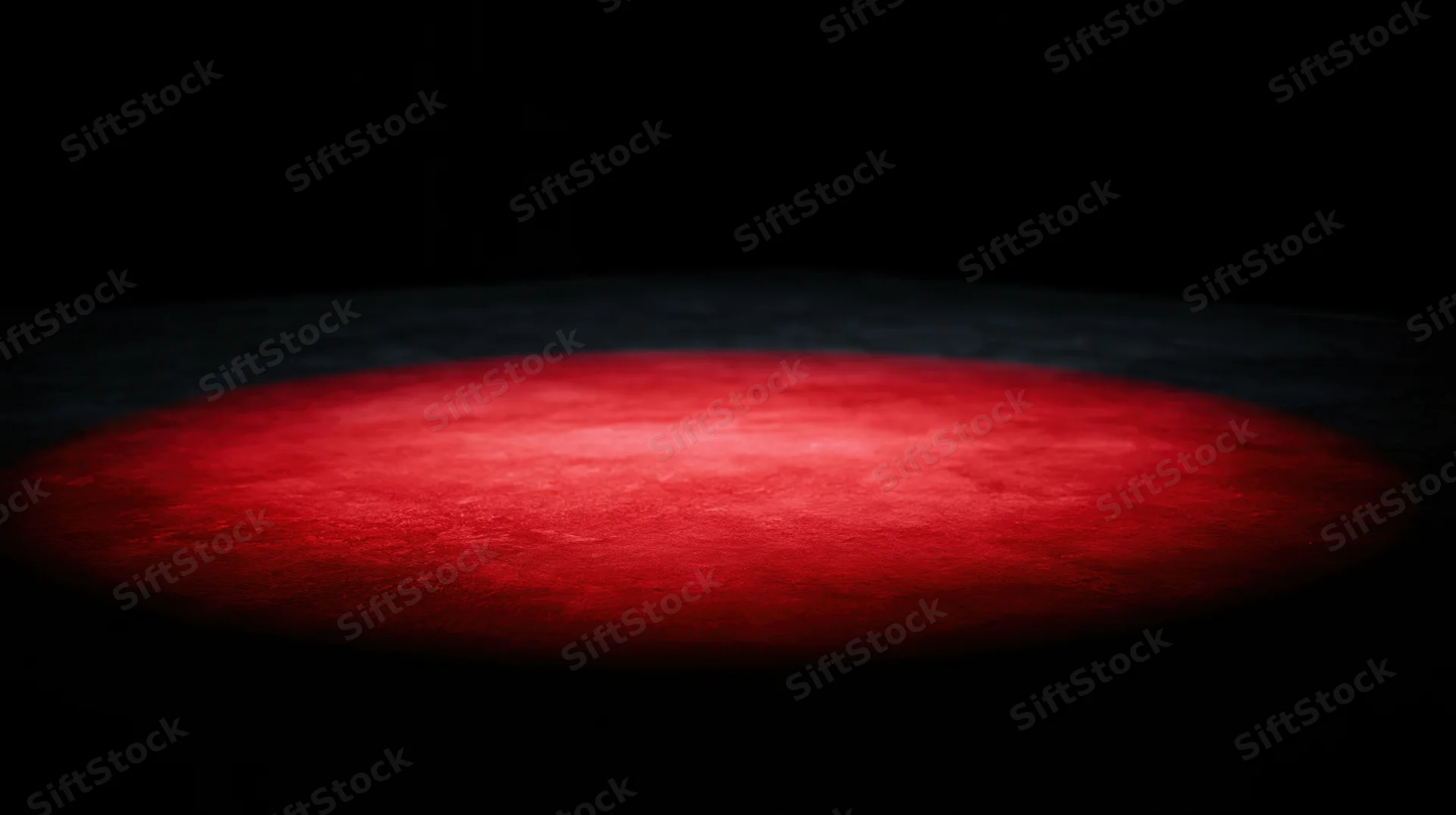 Red spotlight illuminating a dark stage floor