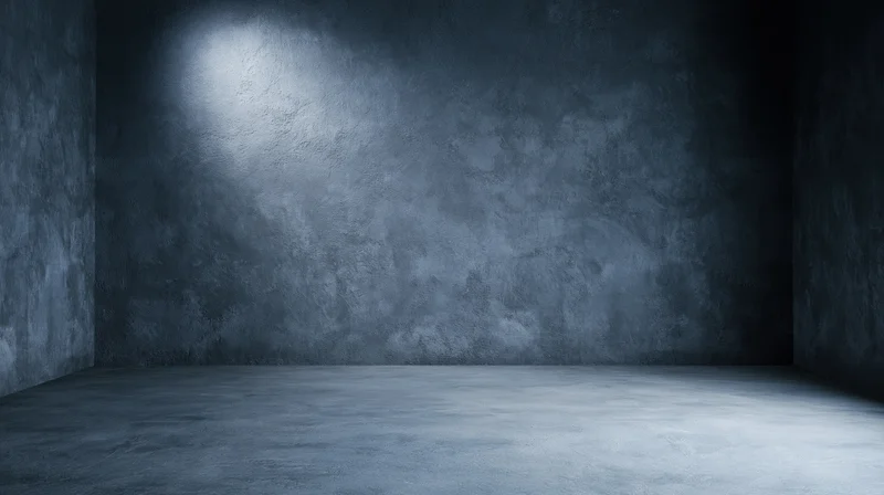 Empty concrete room with spotlight on textured wall and floor
