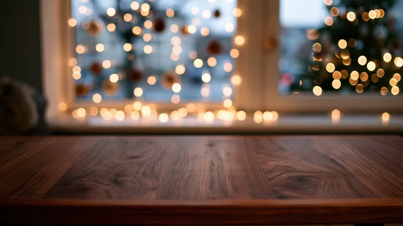 Wooden tabletop in front of a window with blurred christmas lights and holiday decor outside