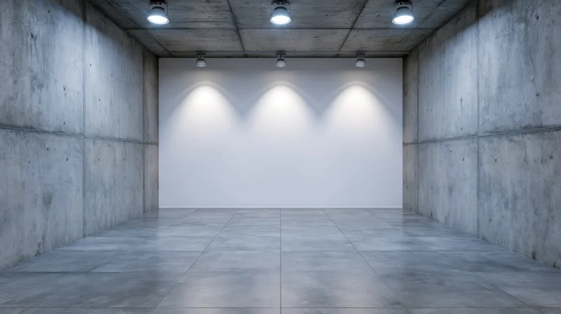 Empty gallery space with white wall and spotlights on concrete interior
