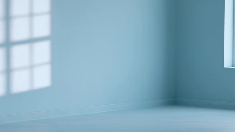 Empty blue room corner with window light and shadow on walls and floor