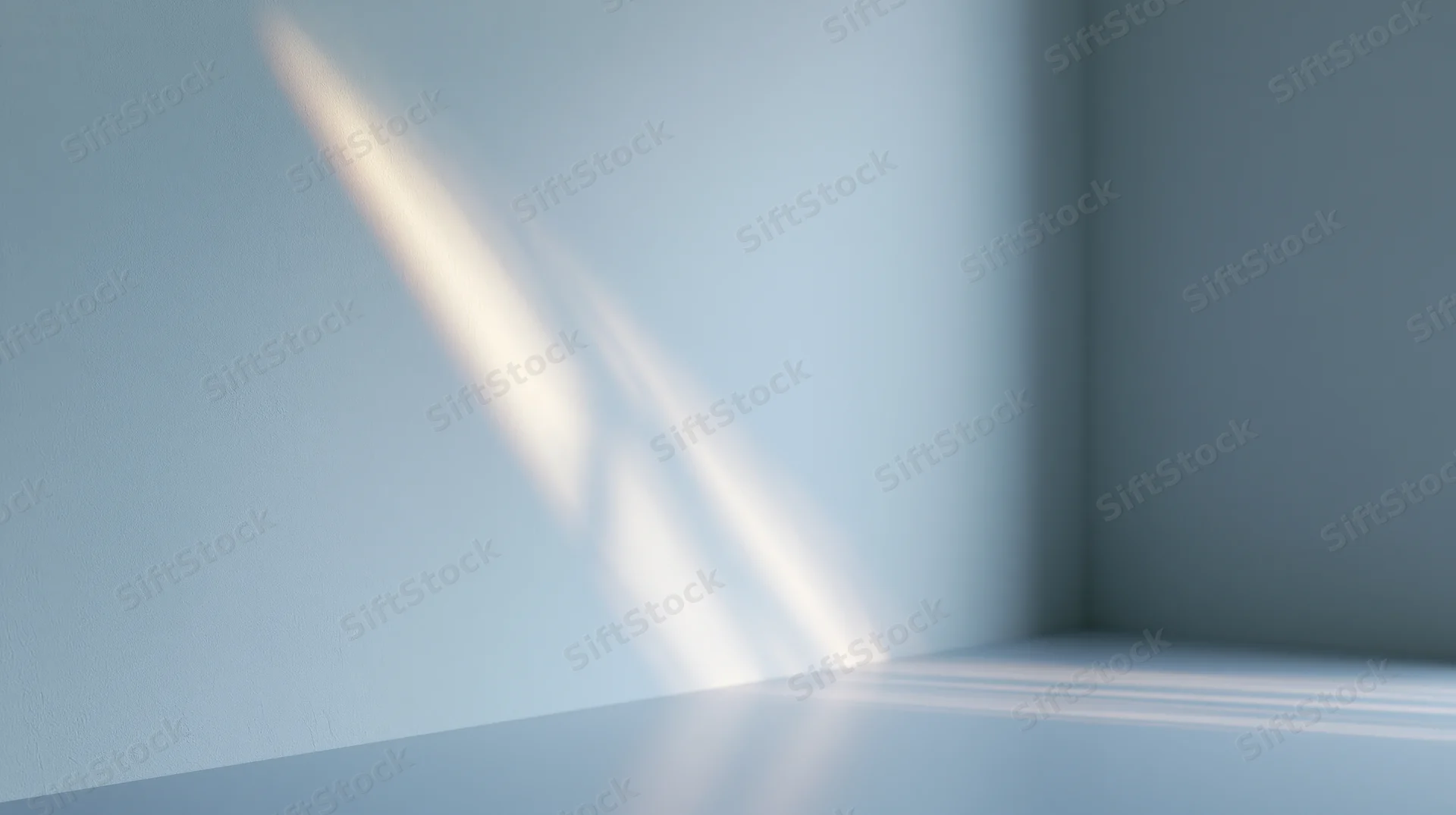 Diagonal light beam casting soft shadow on blue wall and floor in empty room corner