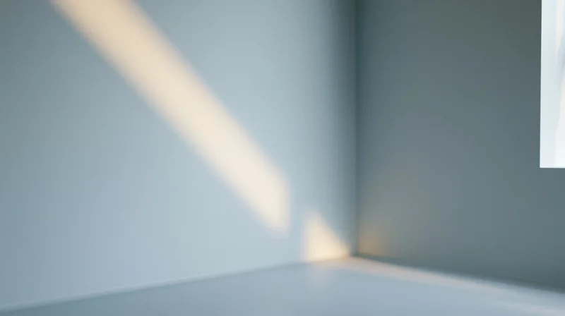 Sunlight casting diagonal shadow across empty corner of minimalist room