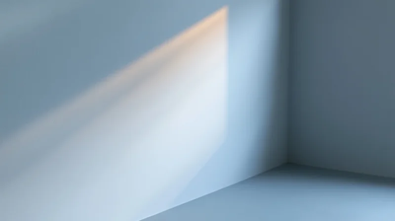A beam of sunlight falling across a blue wall in a quiet room corner